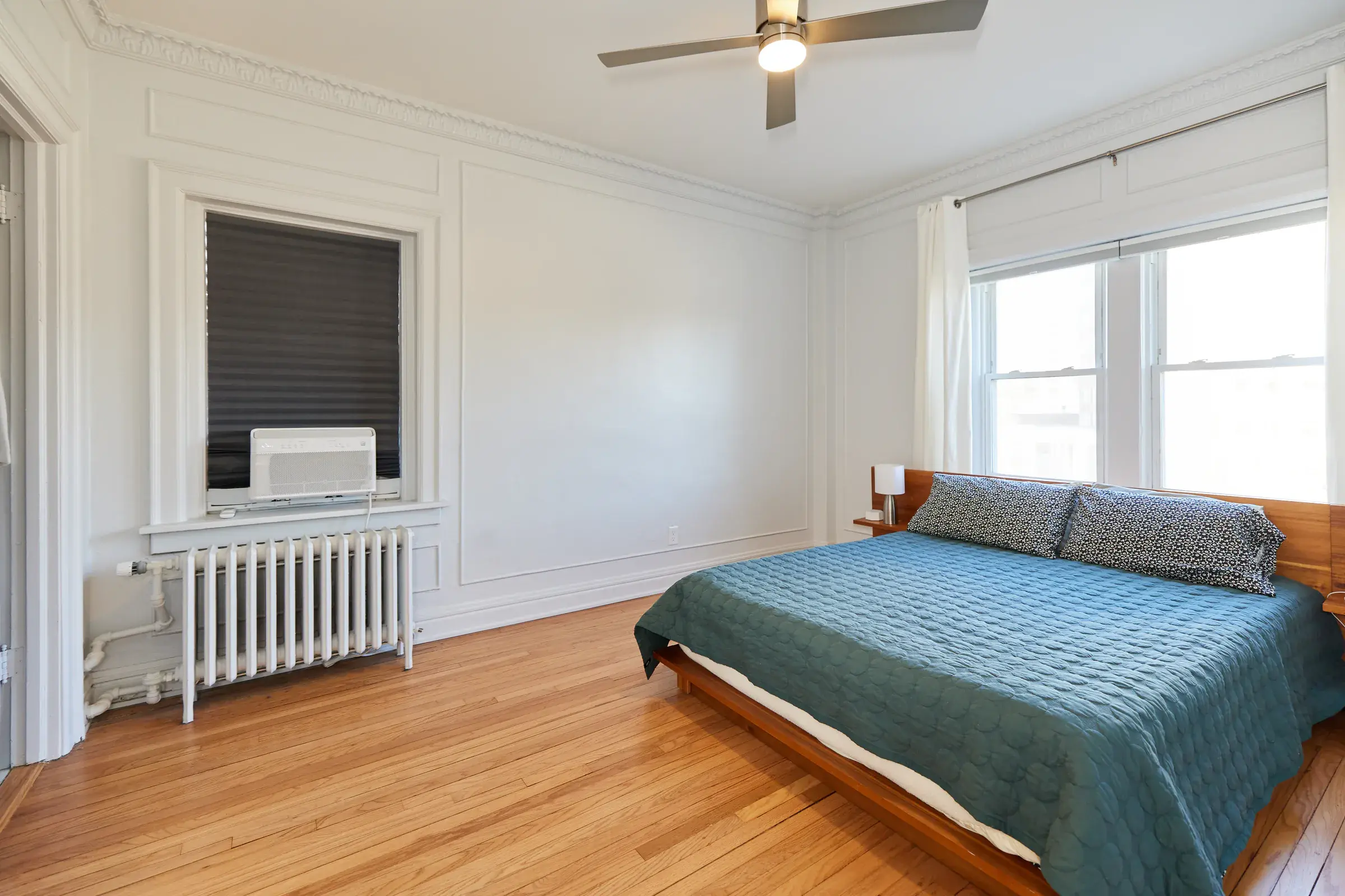 Natural hardwood flooring in a bright apartment bedroom